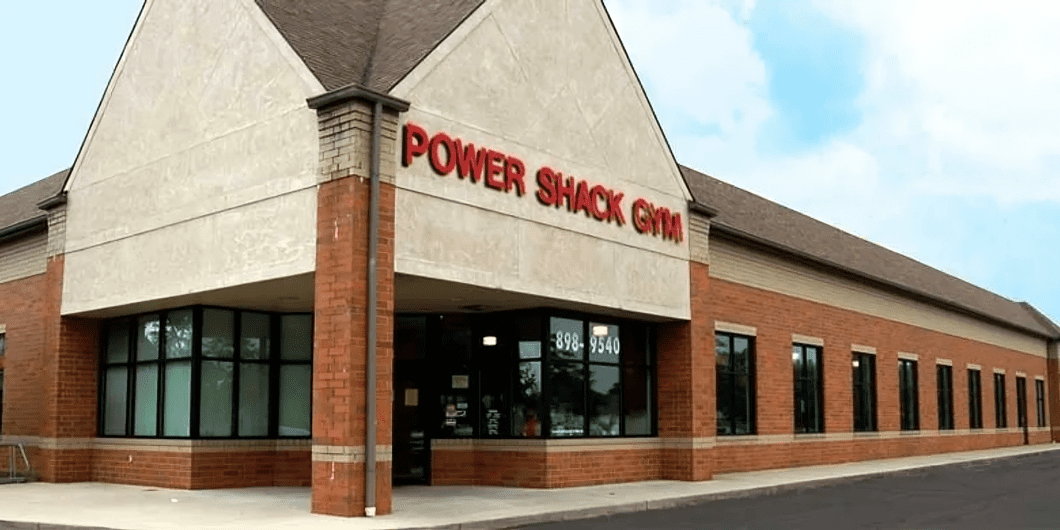 Exterior view of a red-brick building with a sign reading "Power Shack Gym.