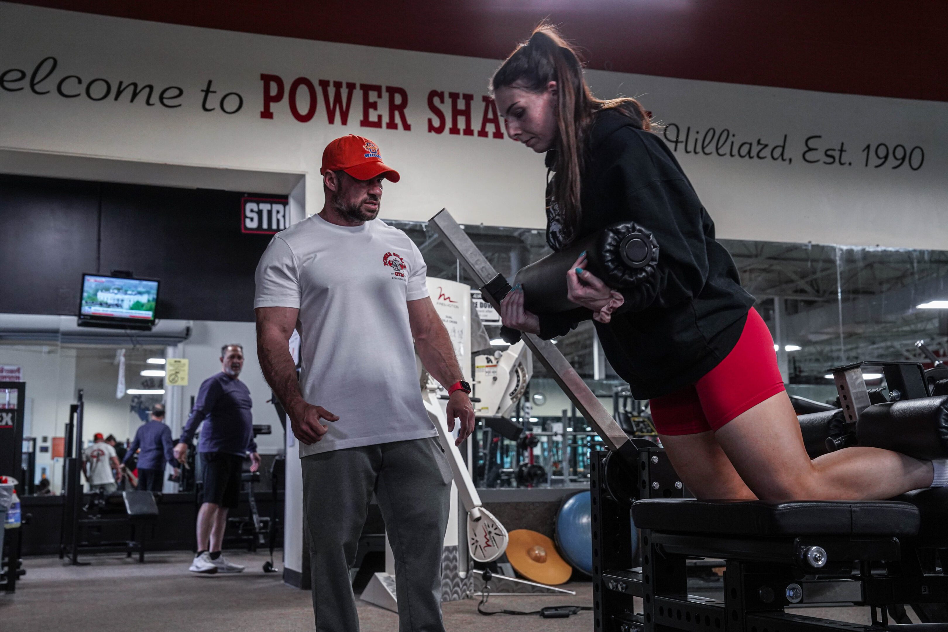 Chris Training PS Background A man and woman are standing in front of some equipment.