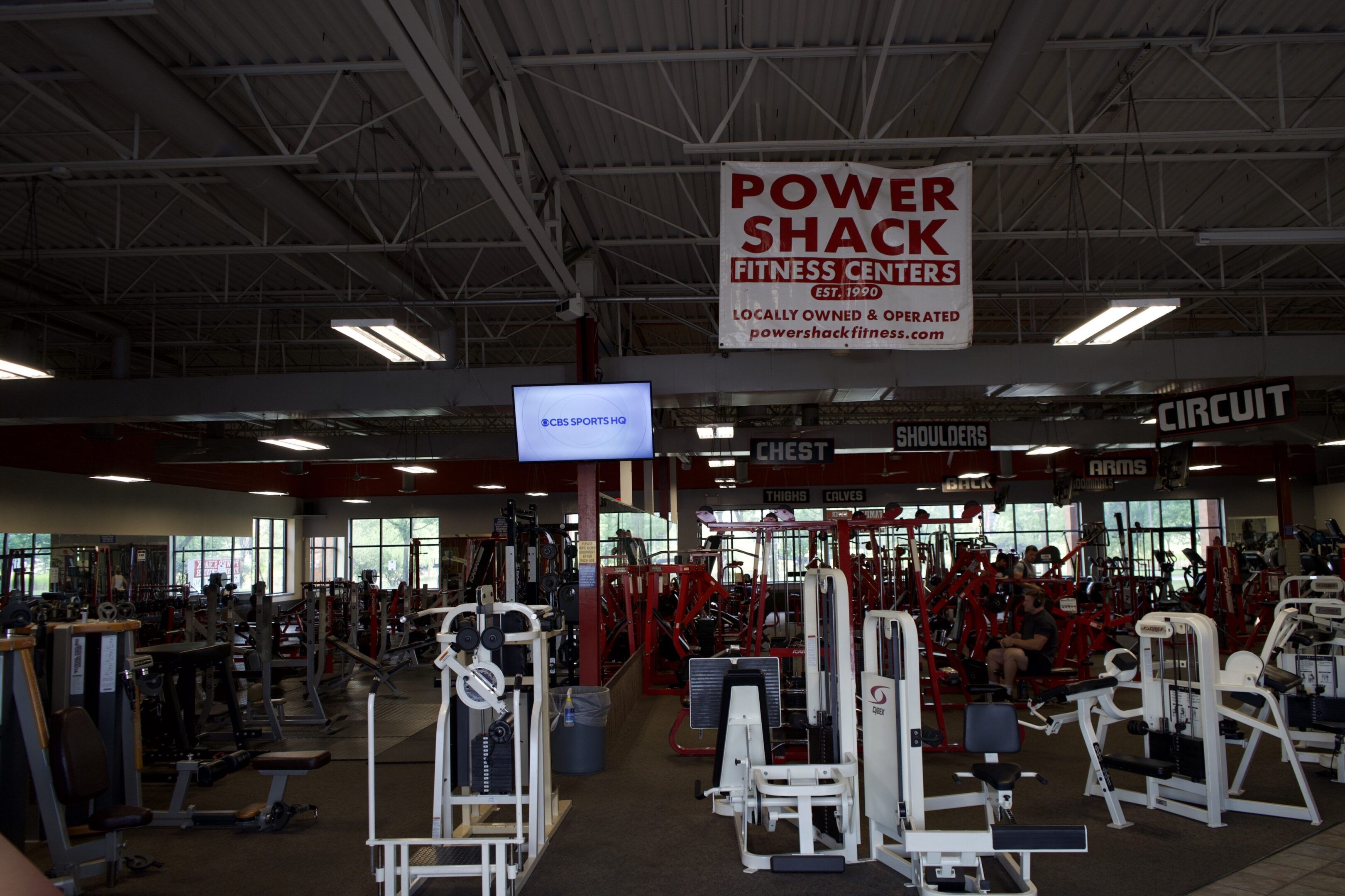 A gym with many people in it and a sign