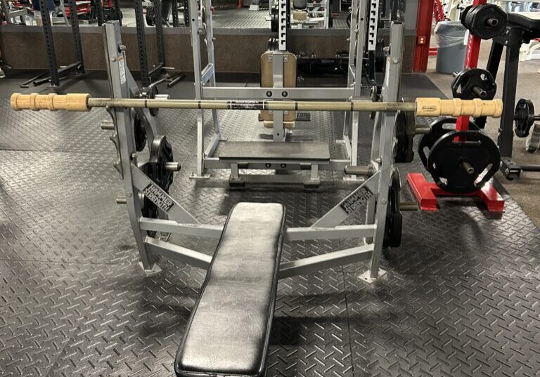 A bench with two bars on it in the gym.