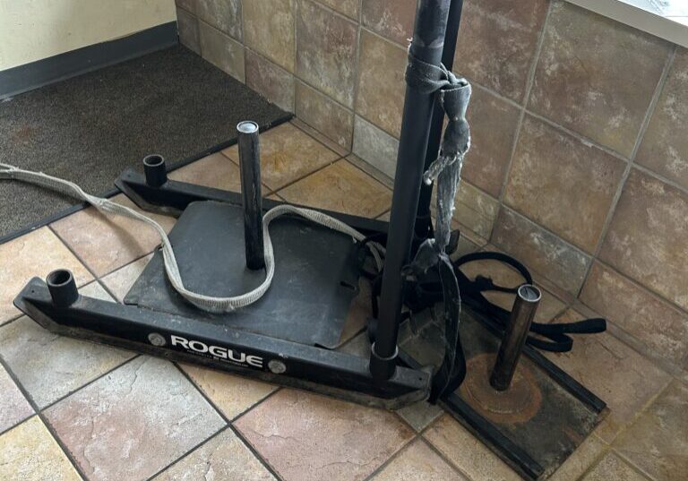 A floor mounted vacuum cleaner sitting on top of tile.